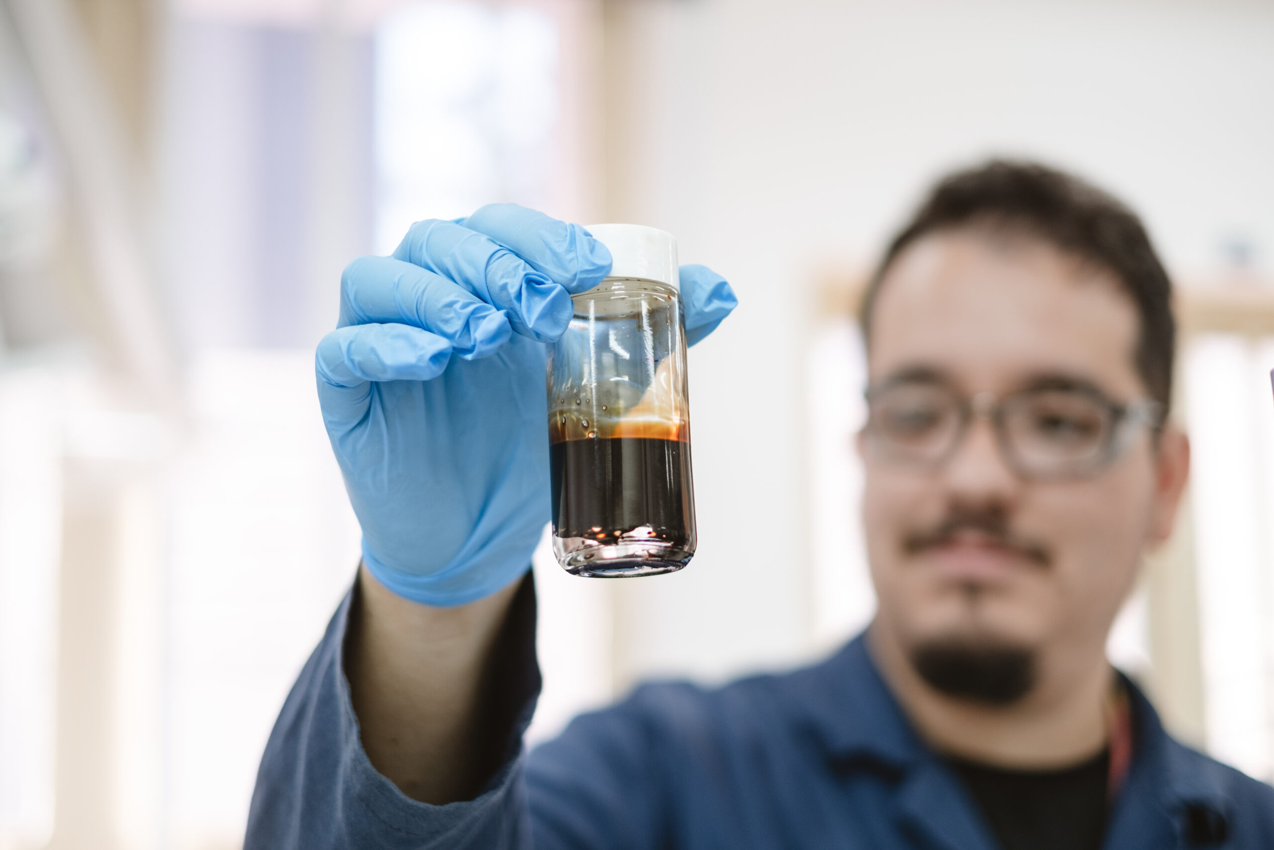 Researcher holding an oil sample.